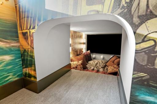 With a secret movie nook (complete with pig snouts), a lofted bed, and a trick portrait that opens into the grand stair, every Purple House room is a storybookânever cookie-cutter.
