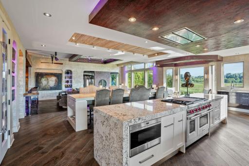 Twin refrigerators, a double oven, and a range crowned by a ceiling hoodâthis is a chefâs stage, framed by Cambria quartz countertops and custom cabinetry.