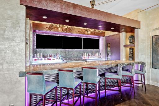 A custom wet bar invites elbows to lean and stories to unfold.
