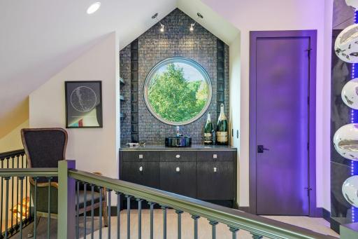A discreet sink and nook for a hotplate or microwave keep the secret soiree alive, a whisper of prohibition glamour disguised as a quiet perch between worlds. Here, the champagne never stops flowing.