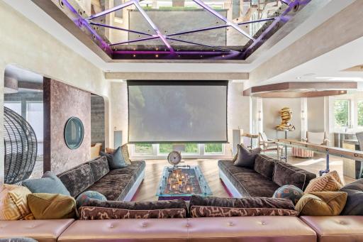Drop-down projection screens, custom furniture, and a two-sided fireplace blur the line between cozy hearth and cinematic spectacle.