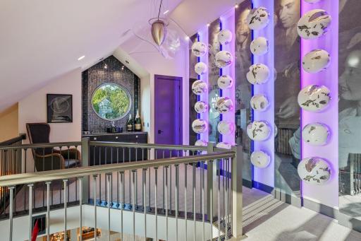 On the upper landing, the walls shimmer with giant orbs, like bubbles forever rising, frozen mid-celebration.