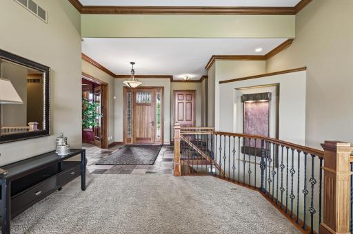 View of front entry area including elevator, stairway wall fountain.
