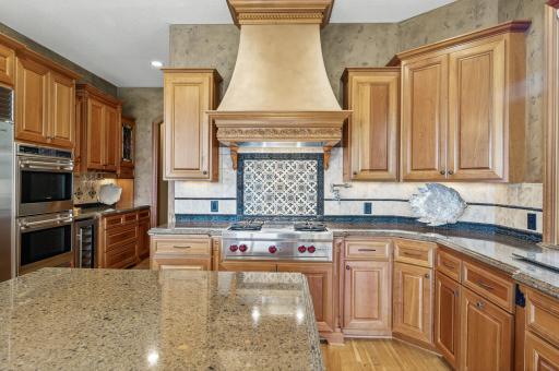 Wolf gas cooktop, double oven, gorgeous granite counters with custom tiled backsplash.