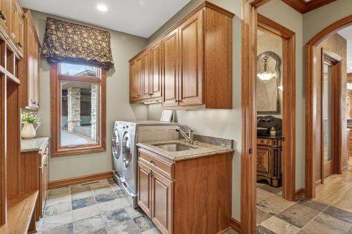 Main floor laundry room with front load washer and dryer, sink and wood locker area open to the mud room as you walk in from the garage area.