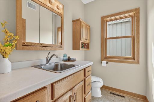 The 1/2 bath has a medicine cabinet/mirror/light combo, ceramic tile flooring, an extra-tall oak vanity cabinet & extra-deep sink, and an air-exchanger connection.