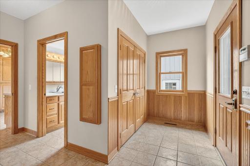 This mudroom, which connects to the front porch, features ceramic tile flooring, wainscoting and a coat storage closet with solid oak French doors. It has an e-lock and a working security system too!