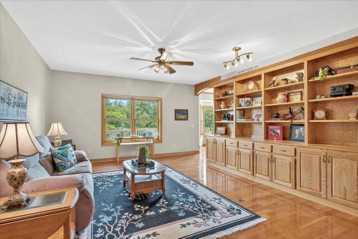 The Living Room features solid oak hardwood flooring, a ceiling fan, and yes --- that bookcase & cabinetry IS INDEED BUILT-IN!