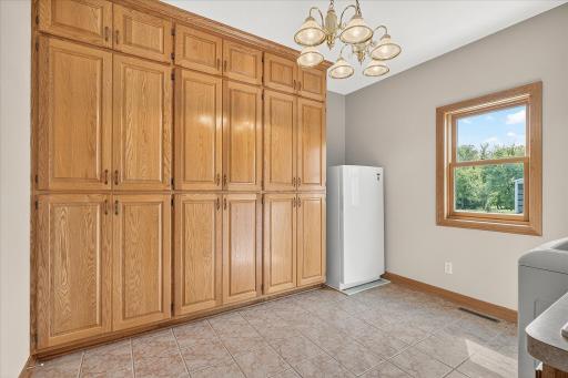 On the other side of the enormous laundry room is this HUGE set of built-in oak cabinets and an upright freezer, that's included in the sale too.
