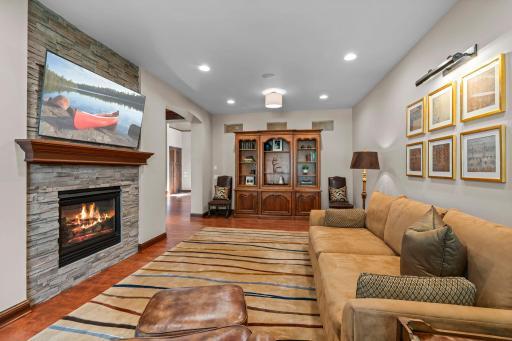 Second living room on main floor, 2 sided gas fireplace with stacked stone, hardwood flooring, recessed lighting, lake views.