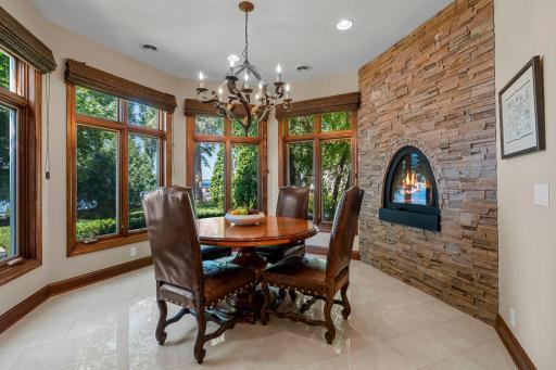 Lake facing Breakfast room with fireplace, stone wall and newly tiled.