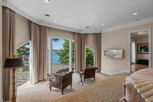 primary sitting area, wall of windows, custom draperies and endless lake views and sunsets.