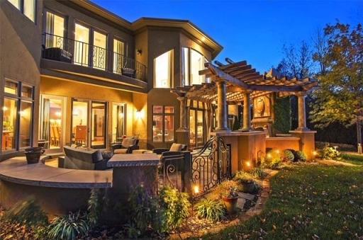 Rear of home features 1/2 wall and built-in bench seating, gas fireplace, pergola, built-in grill, sound, wi-fi and set up to receive TV