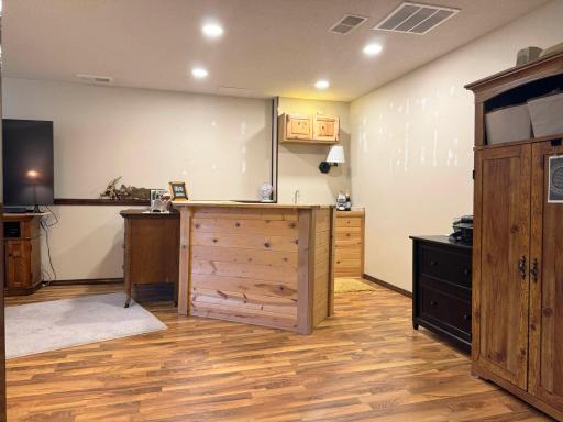 A look at the lower level family room including the charming bar that stays with the property!
