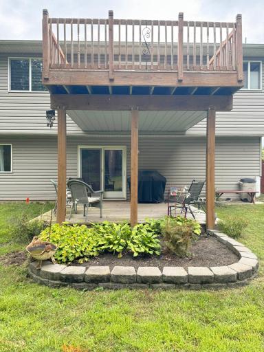 Another angle of the patio with the deck above, featuring the flower bed.