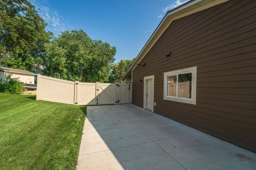 A double gate to the backyard connects to the parking pad. There is a service door from the garage along this side, and on the front door/walkway side.