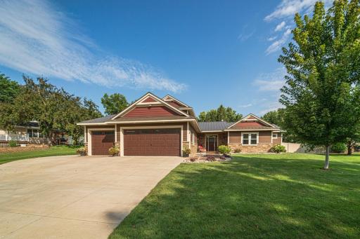 Beautifully-landscaped lot with a concrete driveway and parking pad.