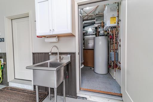Mechanical room, utility sink, and a locking storage area (left door) in the garage.