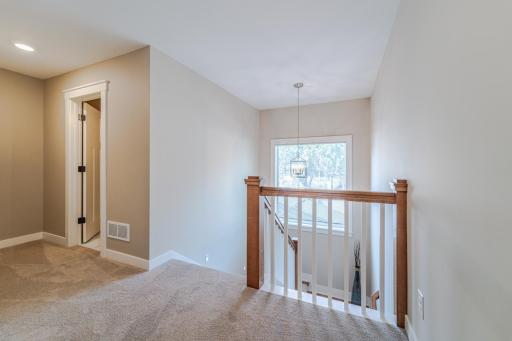 Upper hall landing with lots of light coming in from the stairway landing window