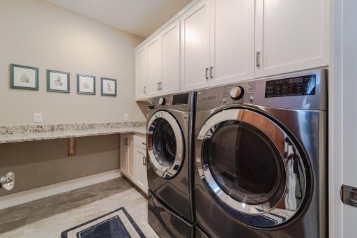The laundry room has a granite countertop, utility sink and cabinetry. This space is clean, bright and spacious.
