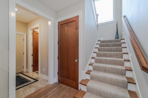 The rear entry has a mud area that connects to the laundry room (door is open) and a closet. A large window on the stairwell landing brightens the rear hall area.