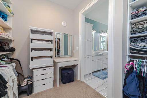 The adjoined walk-in closet with custom organizers and a vanity space with a lighted âsmart mirror.â