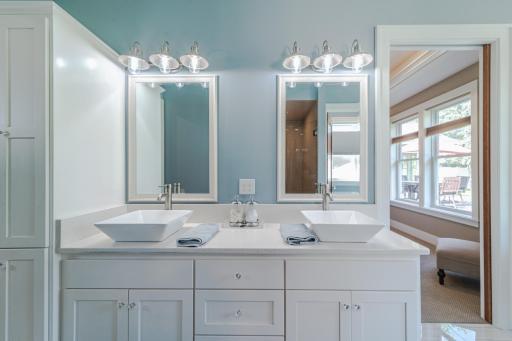 The dual sink vanity has quartz countertops and custom cabinetry.