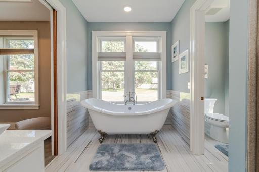 The bath has a hidden pocket door and features a free-standing claw foot tub and private commode.