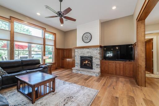 Large windows take in views of the backyard. This room has a ceiling fan.