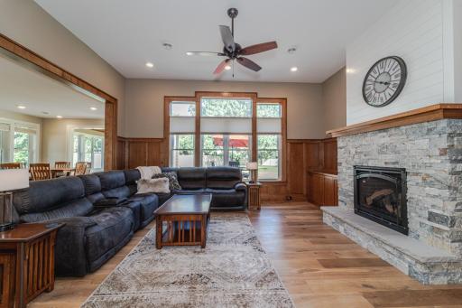 The family room has an 11â6â ceiling, a gas fireplace with stone surround flanked by white oak built-ins, and quarter-sawn white oak paneled wainscoting, up 6â.