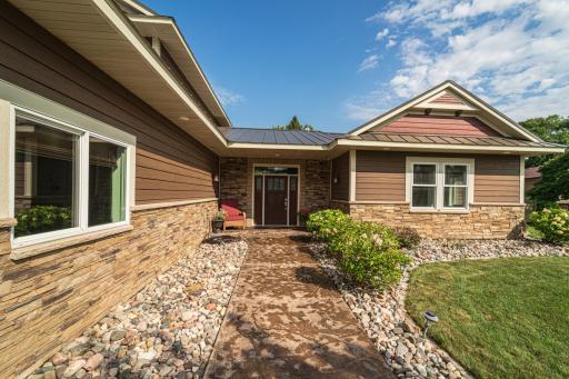 The exterior features LP SmartSide and stone exterior with a steel roof and a stamped concrete front walkway.