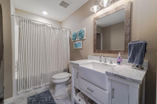 The full bathroom has a farmhouse style sink. A new linen cabinet was custom made and has been installed since this photo was taken.