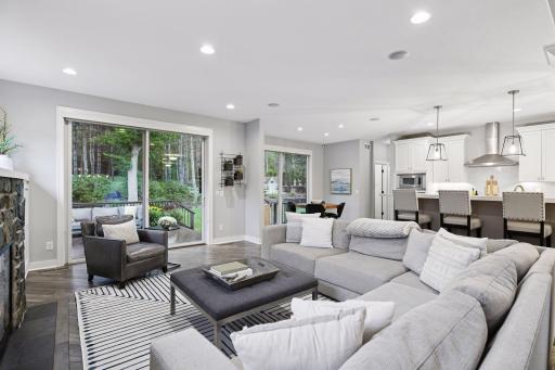 The living room offers a gas fireplace, custom built-in cabinetry, and large sliding glass doors that lead out to the patio and picturesque backyard.