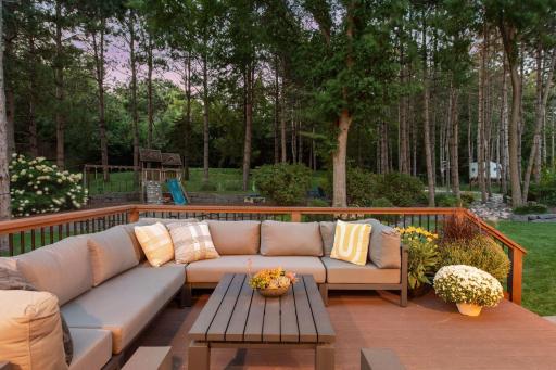 Enjoy the fenced backyard showcasing a private and wooded 0.67-acre lot, patio and deck for outdoor entertaining, stone firepit area, sport court, and charming playhouse, nestled in the mature trees, all surrounded by gorgeous landscaping.
