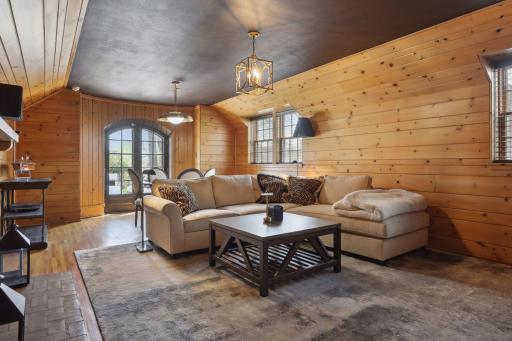 The lower level family room providing a cozy feel with natural woodwork, a painted ceiling, and a gas fireplace.