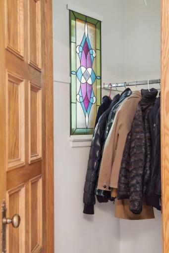 The stained glass adds a touch of privacy to the coat closet.