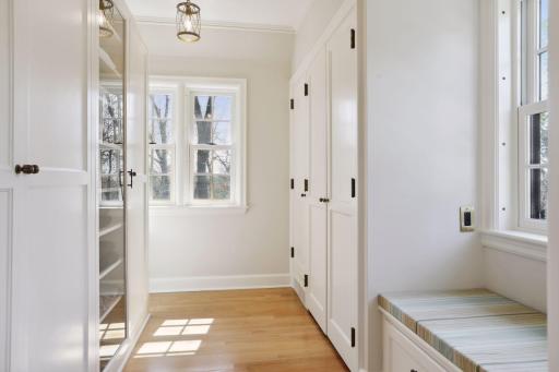 The primary closet space is sophisticated with custom closet spaces and look through glass doors.