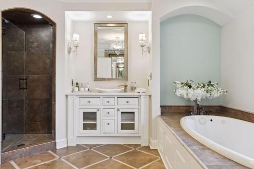 The primary bathroom boasts a soaking tub, dual vanities, a walk in shower, and a private toilet closet.