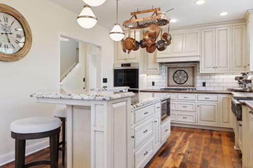 The bright kitchen with granite countertops, tile backsplash, custom cabinetry, and Decor appliances which were new to the home in 2023.