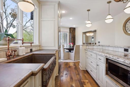 The bright kitchen with granite countertops, tile backsplash, custom cabinetry, and Decor appliances which were new to the home in 2023.