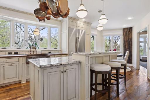 The bright kitchen with granite countertops, tile backsplash, custom cabinetry, and Decor appliances which were new to the home in 2023.