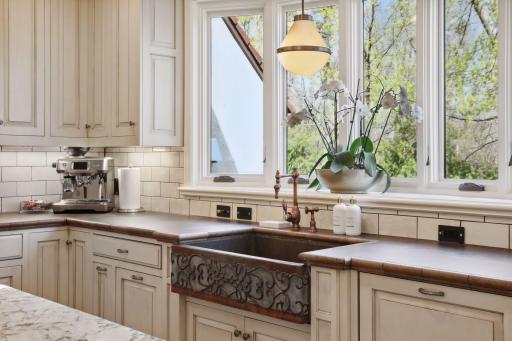 The bright kitchen with granite countertops, tile backsplash, custom cabinetry, and Decor appliances which were new to the home in 2023.