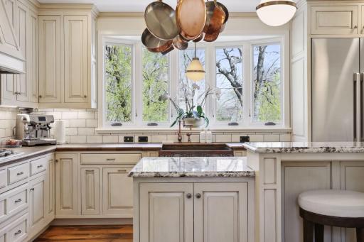 The bright kitchen with granite countertops, tile backsplash, custom cabinetry, and Decor appliances which were new to the home in 2023.