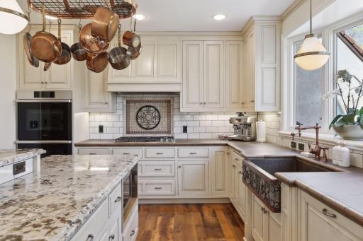 The bright kitchen with granite countertops, tile backsplash, custom cabinetry, and Decor appliances which were new to the home in 2023.