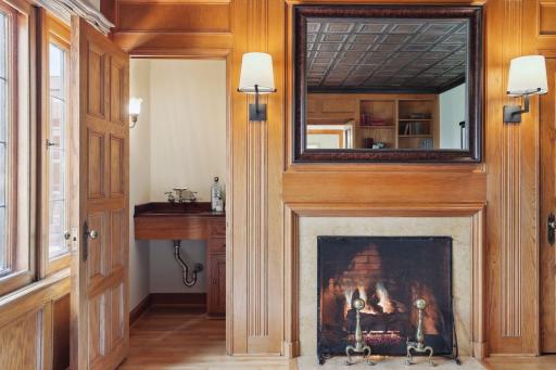 The study features a cozy gas fireplace and a hidden wet bar to enjoy a nightcap.