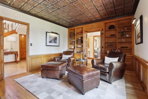The study features a cozy gas fireplace and a hidden wet bar to enjoy a nightcap.