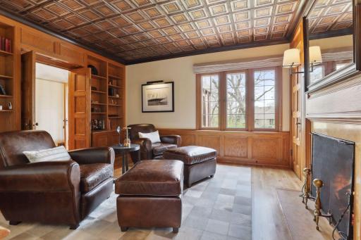 The study features a cozy gas fireplace and a hidden wet bar to enjoy a nightcap.