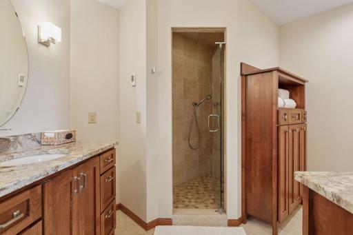 Updated primary suite boasts a stylish tiled walk-in shower.