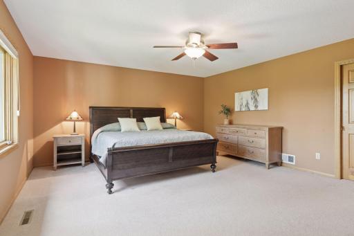 The primary suite boasts a cozy sitting area, custom closet, and an updated bathroom featuring a tiled walk-in shower, dual granite vanities, ample storage with towel and bathroom cabinets, plus luxurious tiled in-floor heating.