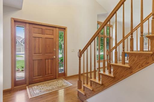 Soaring two-story ceilings grace the foyer and living room, creating a stunning sense of space.